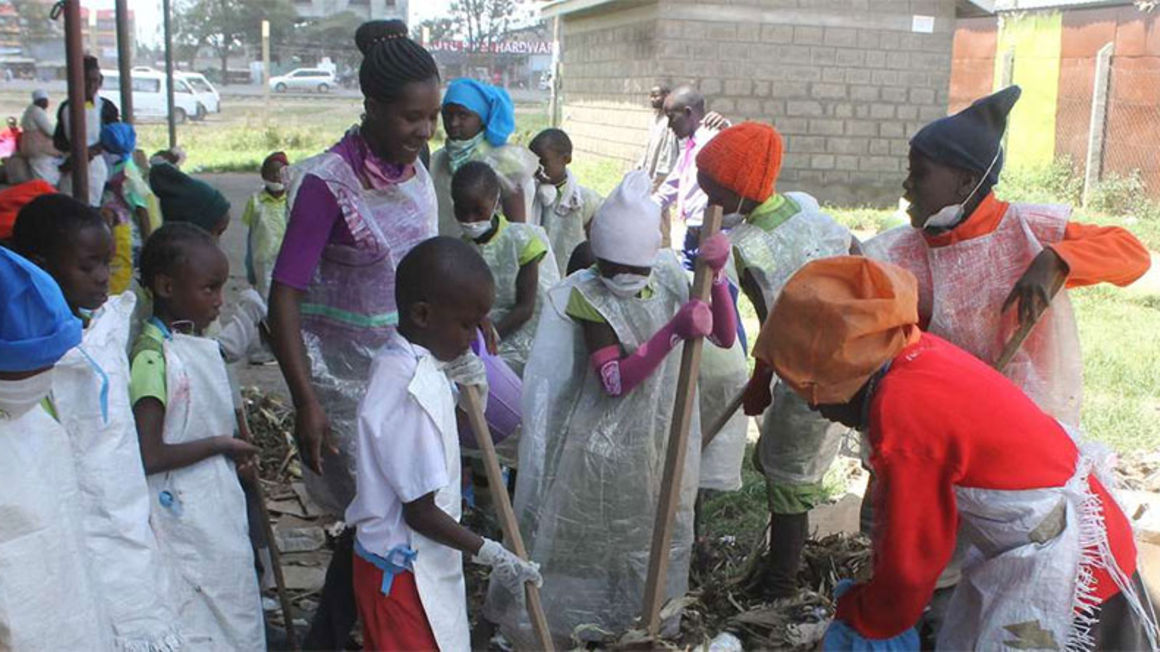 Grade Three pupils at Bridge International Academy in Nakuru, dressed in improvised dust coats, participate in a community clean-up exercise in September last year.
