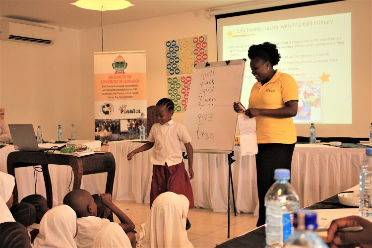 LEARNING THROUGH SOUNDS: Jackline Karisa of Kilifi Primary School demonstrates with her PP2 pupils how the Jolly Phonics works during the Jolly Symposium last year on October 14 in Kilifi.